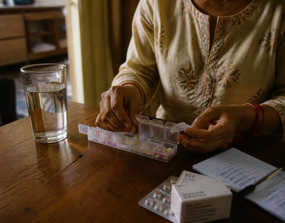 Medicines being organised into a weekly pill box